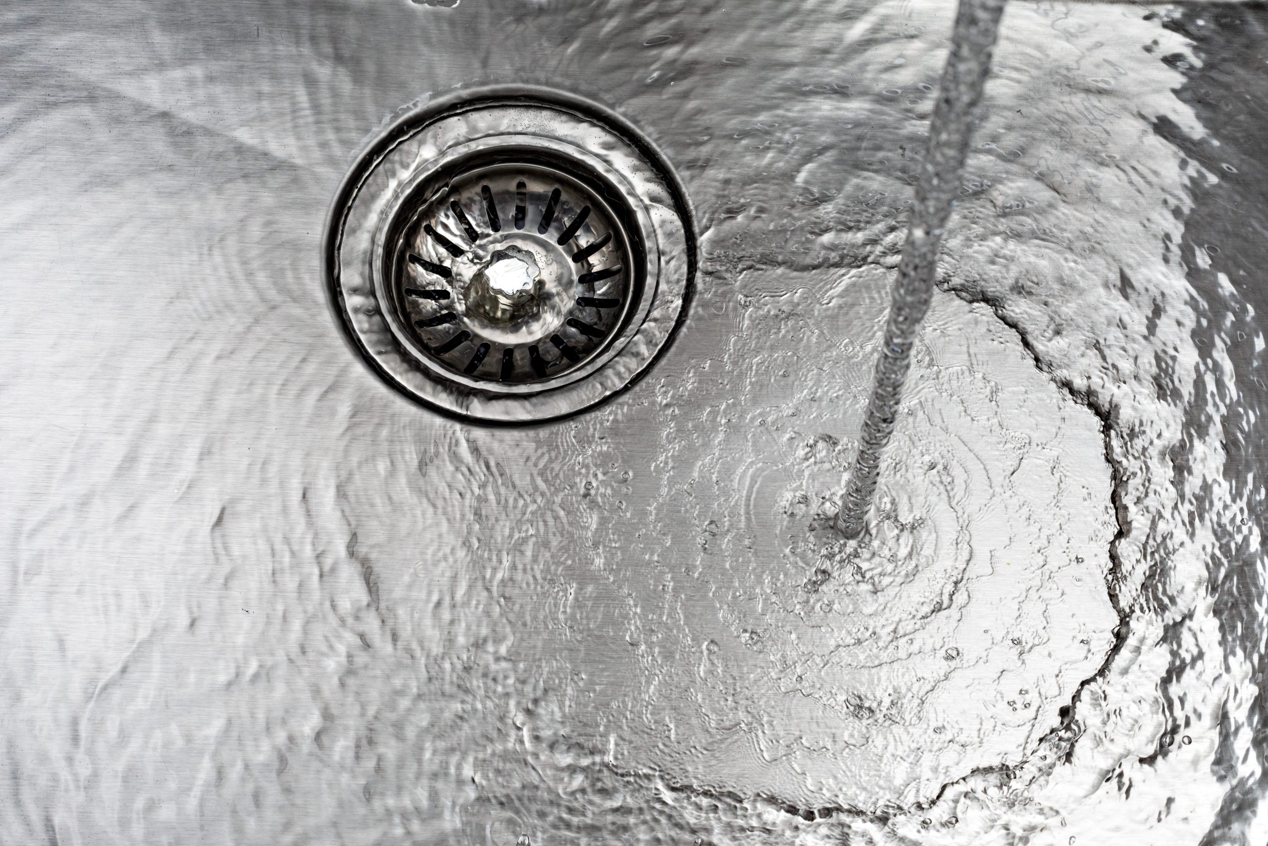 water-drains-down-a-stainless-steel-sink-2026-01-07-07-12-41-utc
